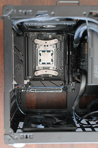"Fully assembled motherboard mounted in the _Jonsbo C6-ITX_ case together with PSU, all cables connected, and top & bottom case fans secured"