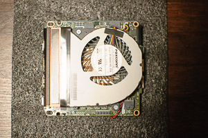 "The _NUC_ motherboard is pulled out and flipped over to reveal the blower fan"